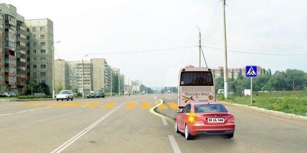 The bus has stopped to yield to a pedestrian. Is the light vehicle driver violating traffic rules in this situation?