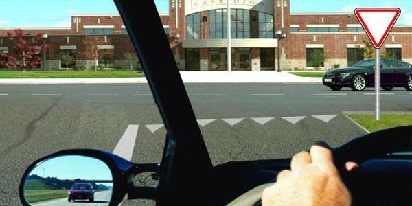 Where should the bus driver stop to yield to the light vehicle driver before continuing to the left?